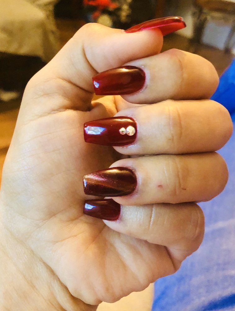 Deep red nails with small rhinestone accents by J Nail Spa